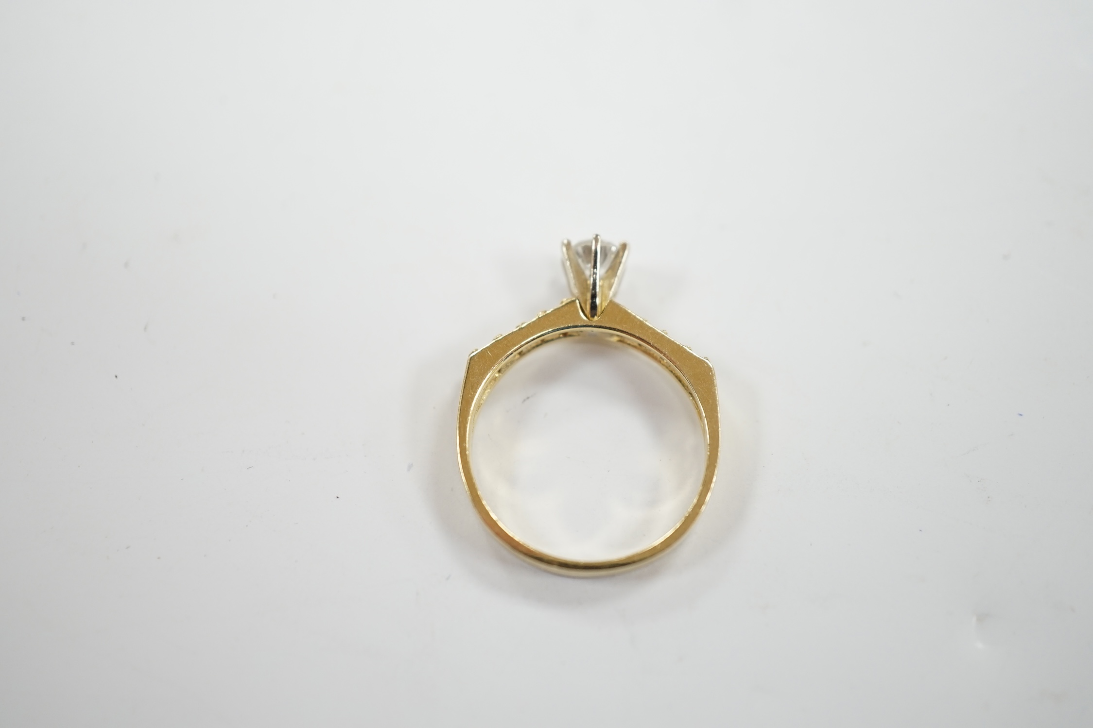 A modern 14k and single stone diamond set ring, with diamond chip set shoulders, size M, gross weight 2.7 grams.